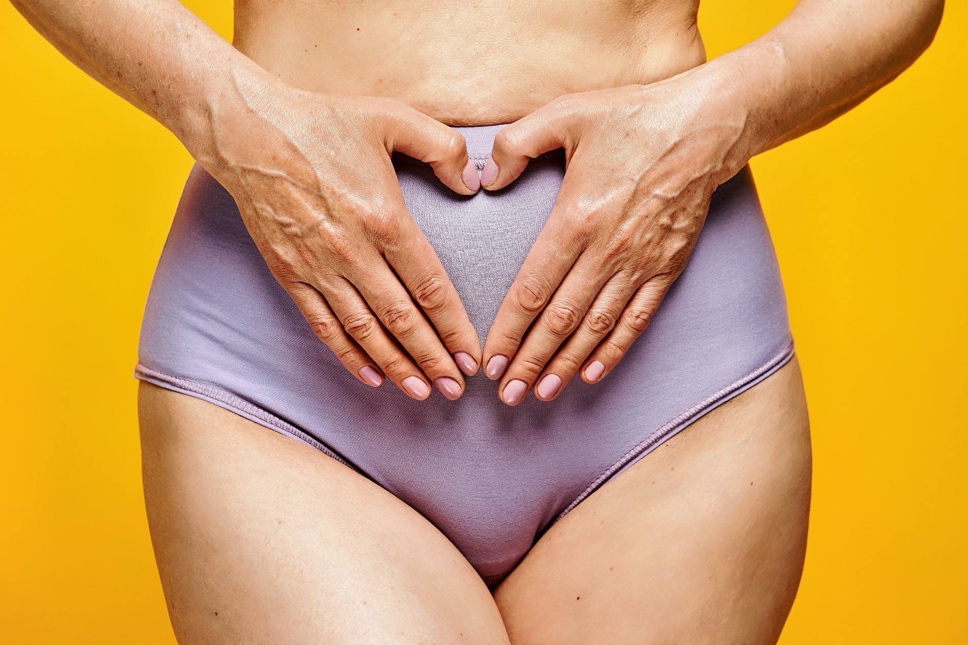 Foto des Unterleibs einer Frau mit lila Unterhose Foto des Unterleibs einer Frau mit lila Unterhose